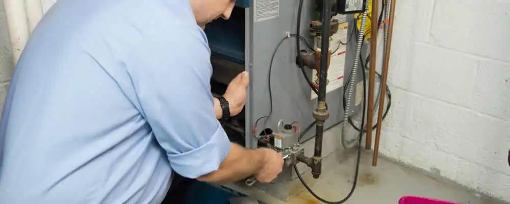 Furnace repair technician inspecting and servicing a home heating system in Denver, CO