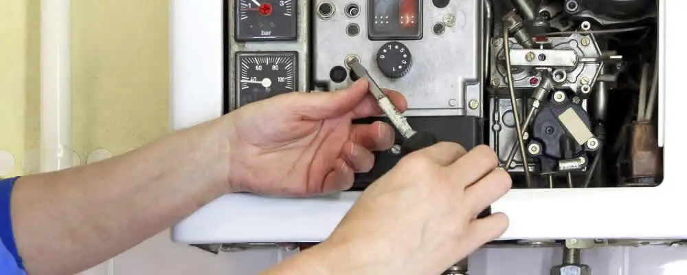 Heating repair technician adjusting boiler controls and components in Denver, CO