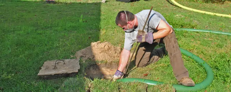Septic pumping technician servicing a residential septic tank in Denver, CO